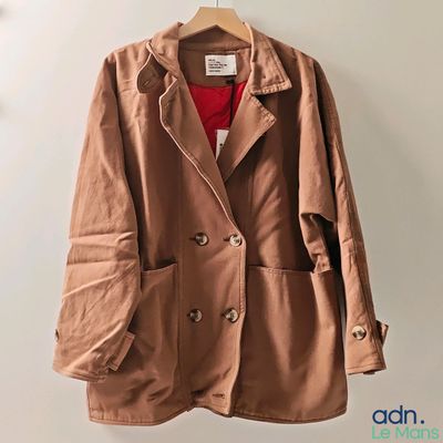 a close up of a jacket hanging on a hanger on a wall
