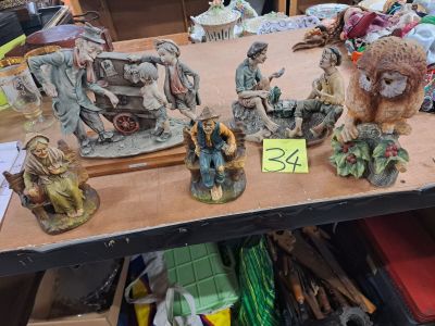 de nombreuses figurines posées sur une table, accompagnées d'une étiquette de prix