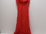 the red dress is hanging on a hanger on a white wall