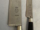 two knives sitting next to each other on a table