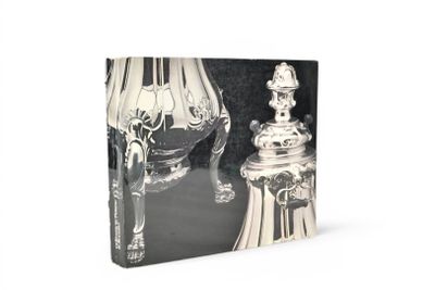 un livre sur lequel figure l'image d'un vase en argent et d'une lampe