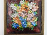 tableau représentant un bouquet de fleurs dans un cadre doré, accroché à un mur blanc