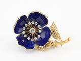 une image représentant une broche en forme de fleur bleue sur fond blanc