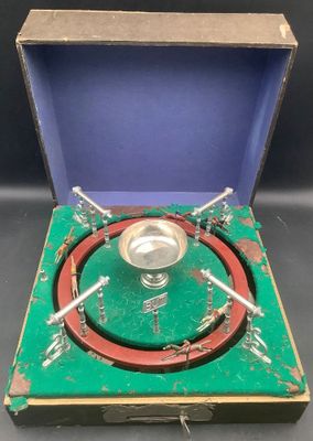 un petit objet métallique dans une boîte verte ornée d'un anneau rouge