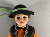 a doll that is wearing a hat and a dress