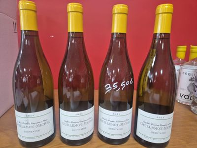quatre bouteilles de vin sont alignées sur une table