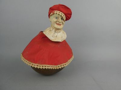 une figurine représentant une femme vêtue d'une robe rouge et d'un chapeau rouge