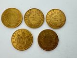 four gold coins are arranged in a row on a white surface