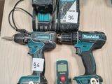 Deux Makita sont posées sur une table à côté d'une boîte à outils