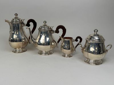four pieces of silver tea and coffee set on a white surface