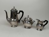 three pieces of silver tea and coffee set on a white surface