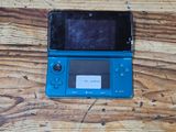 a blue nintendo wii game console sitting on a wooden table