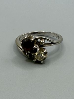 une bague en argent ornée d'un grenat et d'un motif floral