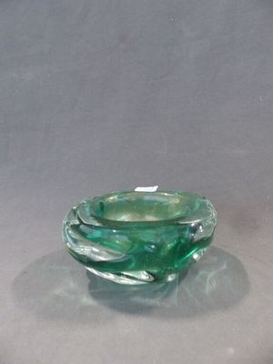 un saladier en verre vert posé sur une table