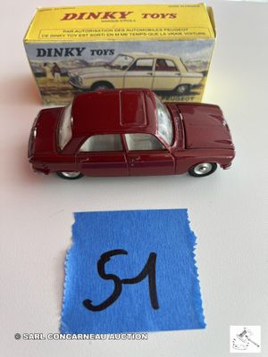 une petite voiture rouge posée sur une table, à côté d'un tissu bleu