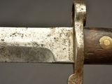 a close up of a knife on a wooden pole
