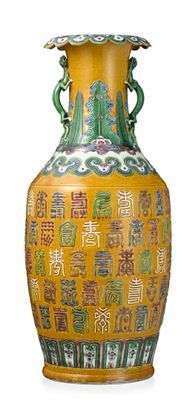 un vase jaune orné d'inscriptions asiatiques sur fond blanc