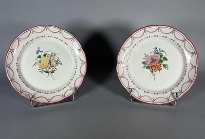 deux assiettes ornées de motifs floraux, posées sur une surface grise