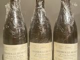 three bottles of wine wrapped in plastic sitting on a counter