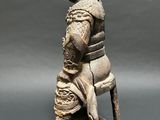an image of a statue of a man sitting on a stool