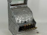 an old fashioned cash register sitting on top of a white surface