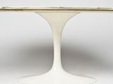 a white table with a marble top and pedestal base