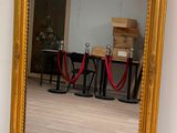 un grand miroir au milieu d'une pièce, avec une corde rouge