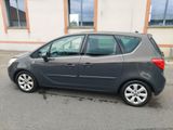 La voiture grise est garée devant un immeuble dans la rue.