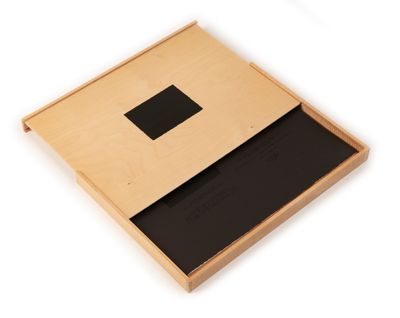 an open wooden box with a black square in it