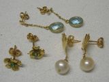 deux paires de boucles d'oreilles et une paire de boucles d'oreilles posées sur une table