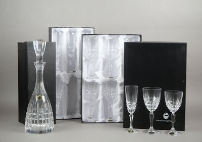 trois verres à vin, une carafe et une carafe dans une boîte