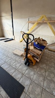un petit chariot chargé d'une pile de bois dans une pièce