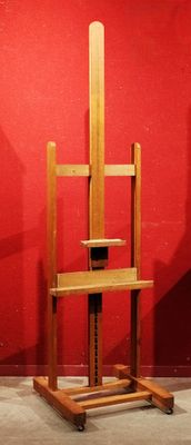 une chaise en bois posée sur un socle, adossée à un mur rouge