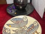 une assiette sur laquelle est représenté un oiseau, posée sur une table
