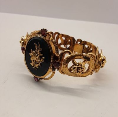 an image of a gold bracelet with a black stone in the center