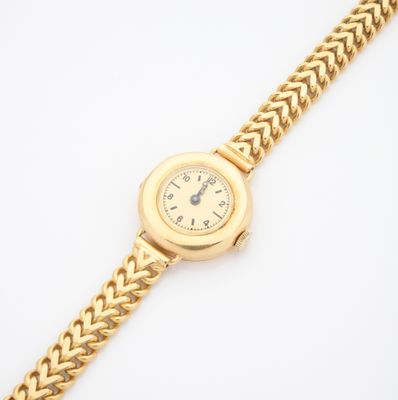 Gros plan sur une montre-bracelet en or entourée d'une chaîne