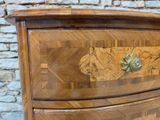 a wooden chest of drawers with a decorative design on it