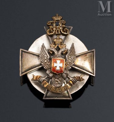a silver and gold medal with a red cross on it