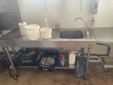 a kitchen with a sink and a metal counter