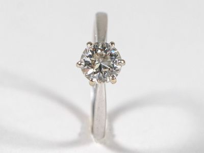 gros plan d'une bague en diamant sur une surface blanche