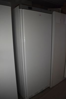 Trois réfrigérateurs blancs sont alignés contre un mur dans une pièce