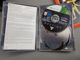 a cd in the case on the table next to a book