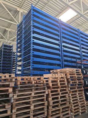 pallets stacked up in a warehouse with lots of blue pallets