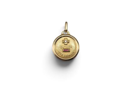 a small gold locke with a pink stone in the center