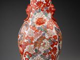 an orange and white vase with a floral design on it