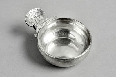a silver spoon with a coin in it on a table