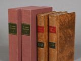 three books sitting on top of each other on a gray surface