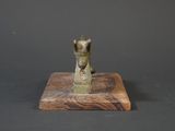 statue of a horse on a wooden base on a black background