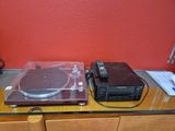 un tourne-disque et une platine posés sur une table en verre
