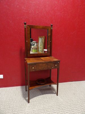 une petite table en bois sur laquelle se trouve un miroir